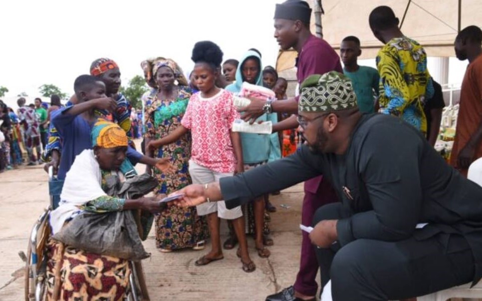 Honourable Abdulrasheed Kashamu distributing cash and food items to a crowd at his residence in Ijebu Igbo during the Eid-el Kabir celebration.