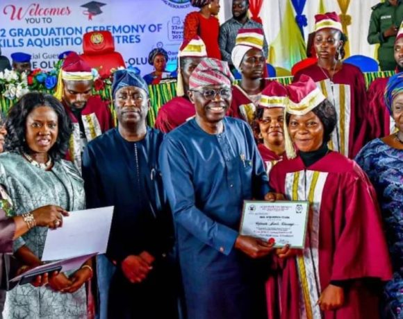 A group of skill acquisition graduates in Lagos holding their start-up packs at the graduation ceremony.