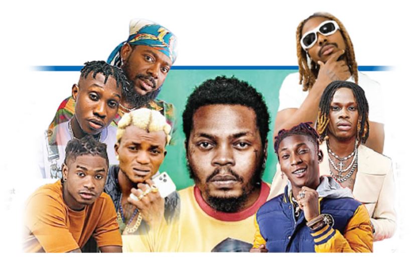 Olamide mentoring and supporting artists like Fireboy DML, Asake, Adekunle Gold, and Lil Kesh, showcasing his leadership and impact on their careers. 