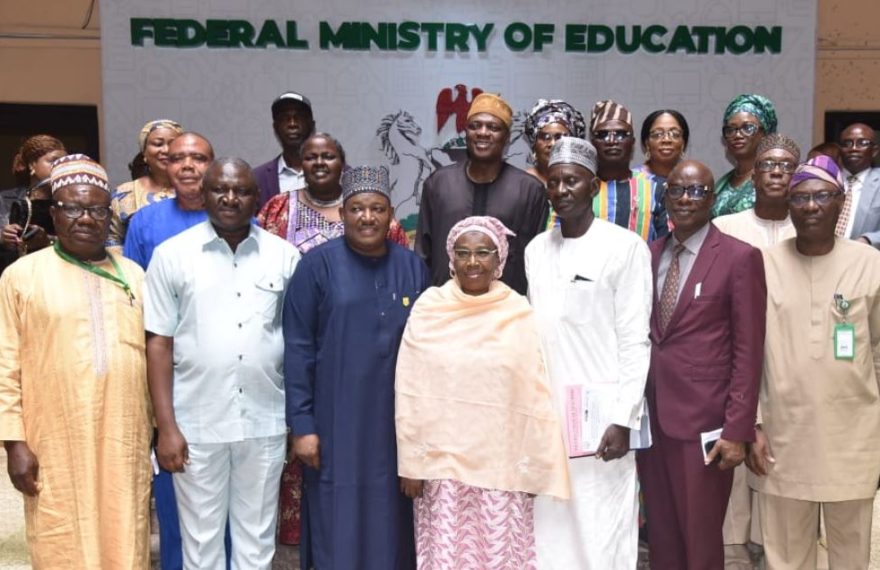 A group of Nigerian teachers in a classroom, engaging with students.