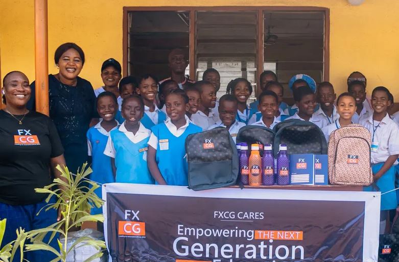 FXCG team presenting school bags and stationery to pupils of Kuramo Primary School, engaging in interactive sessions with teachers and students.